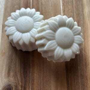 White flower-shaped soaps on wooden surface.