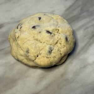 Chocolate chip cookie on marble surface.