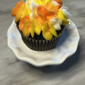 Colorful cupcake on a white plate.