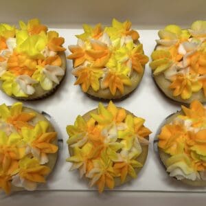 Cupcakes with yellow and orange flower frosting.